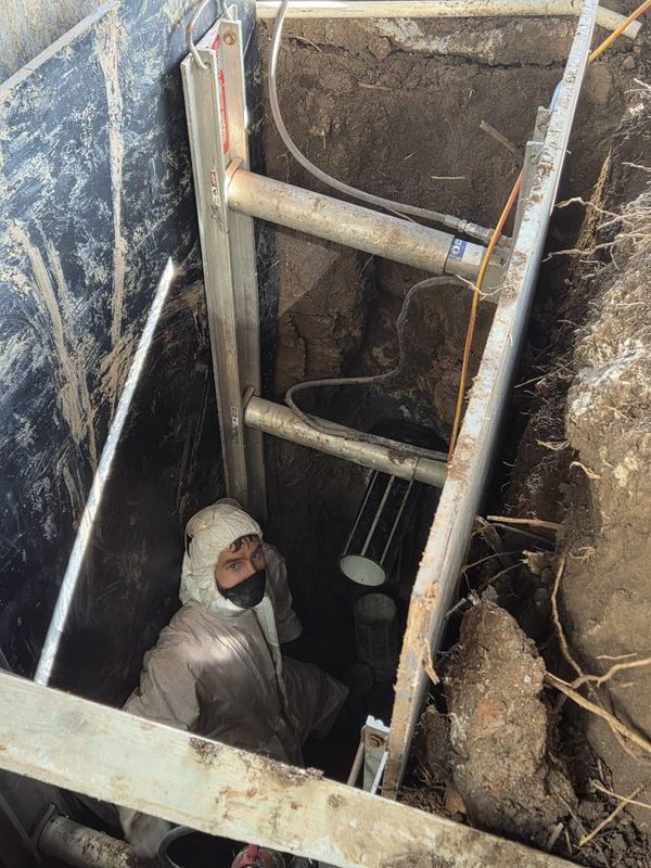 Invertex team member in PPE working in a deep shored pit