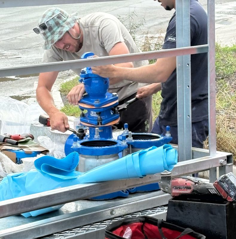 Team assembling blue ductile iron valve fittings for a water main